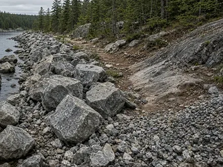 Large armour stone blocks set along a rocky shoreline