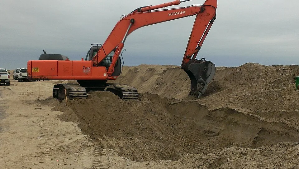 Excavator digging a trench in open ground
